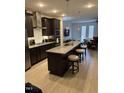 Modern kitchen with stainless steel appliances, dark cabinets, and a large center island at 1833 Fahey Dr, Apex, NC 27502