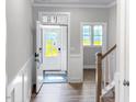 Bright foyer with hardwood floors, white wainscoting, and a staircase leading to the upper level at 1849 Ballard Rd # Holly Georgian, Fuquay Varina, NC 27526