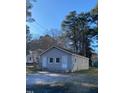 A charming gray house with a symmetrical facade and lush tree backdrop at 207 Booth Ave, Henderson, NC 27536