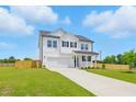 Attractive two-story white home featuring a well-kept lawn and a spacious driveway leading to a two-car garage at 22 Whistling Way # 18, Lillington, NC 27546