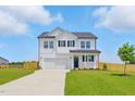 Classic two-story white home with a neat front lawn and a convenient driveway leading to an attached two-car garage at 22 Whistling Way # 18, Lillington, NC 27546