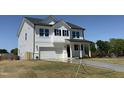 Beautiful two-story home with white siding, black shutters, a covered porch, and an attached garage at 22 Whistling Way # Holly Farmhouse, Lillington, NC 27546