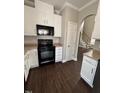 Open kitchen showcasing white cabinets, black appliances, and hardwood floors at 3144 La Costa Way, Raleigh, NC 27610