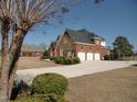 A two-story home with brick facade and three-car garage, complemented by a spacious driveway at 325 Sandy Ridge Rd, Dunn, NC 28334