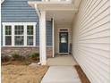 Inviting entryway with a stylish blue door, stone accents, and ample natural light at 366 Tormore Dr, Sanford, NC 27330