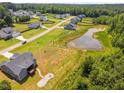 Aerial view of property featuring a pond, fire pit and fenced-in back yard at 40 Cinnamon Teal Way, Youngsville, NC 27596