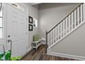 Welcoming foyer featuring a staircase, light gray walls, wood-look flooring and a white front door with sidelight at 40 Cinnamon Teal Way, Youngsville, NC 27596