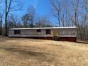 Exterior view of single-story home featuring horizontal siding and red window shutters at 415 Island Creek Estates Rd, Henderson, NC 27537