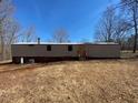 Exterior view of a single-story mobile home with yard and blue sky at 415 Island Creek Estates Rd, Henderson, NC 27537