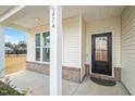 Inviting front porch featuring brick accents and a black front door, creating a warm welcome at 474 W Ravano Dr, Clayton, NC 27527