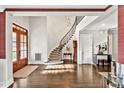 Welcoming foyer with hardwood floors, curved staircase, and abundant natural light from the front door at 5040 Shakori Trl, Chapel Hill, NC 27707