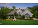 Inviting two-story home with painted brick, manicured landscaping, and unique greenery covered entrance at 5040 Shakori Trl, Chapel Hill, NC 27707