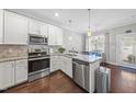 Modern kitchen boasts white cabinetry, granite countertops, stainless steel appliances, and a breakfast bar at 510 Mariah Towns Way, Garner, NC 27529
