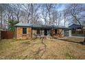 Beautiful brick home with shutters, front porch, and mature trees creating a cozy atmosphere at 5819 Windham Dr, Raleigh, NC 27609