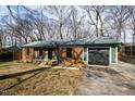 Charming brick home with an attached garage and mature trees creating a serene outdoor space at 5819 Windham Dr, Raleigh, NC 27609