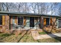 Close-up of a brick home's charming front porch with seating, shutters, and inviting curb appeal at 5819 Windham Dr, Raleigh, NC 27609