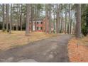 Classic two-story brick house with black shutters nestled in a wooded lot at 636 Palmer Dr, Sanford, NC 27330