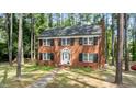 A charming brick home featuring black shutters surrounded by mature trees and greenery at 636 Palmer Dr, Sanford, NC 27330