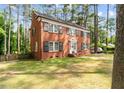 Traditional brick two-story home with black shutters and well-maintained landscaping in wooded area at 636 Palmer Dr, Sanford, NC 27330