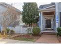 Inviting front porch with brick pathway, well-manicured landscaping, and a charming white picket fence at 705 Highgrove Dr, Chapel Hill, NC 27516