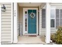 Inviting front entryway with a teal door, decorative wreath, and covered porch at 708 Pitchback Mill Ct Ct, Wake Forest, NC 27587