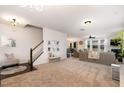 Spacious living room with plush carpeting, a staircase, and seamless transition to the dining area at 708 Pitchback Mill Ct Ct, Wake Forest, NC 27587