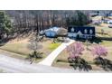 Sprawling property featuring a lovely home, detached garage, beautiful landscaping, and inviting driveway at 105 Glasgow Dr, Clayton, NC 27520