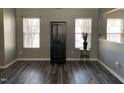 Open-concept living room with wood flooring, neutral paint, and natural light at 1208 Shining Water Ln, Creedmoor, NC 27522