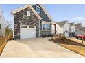 The exterior features stone accents, one-car garage, concrete driveway, and low-maintenance landscaping at 1215 White Flint Cir, Durham, NC 27703