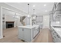 Modern kitchen with gray cabinets, a spacious island, and open access to the living room at 122 Sanderway Dr, Chapel Hill, NC 27516