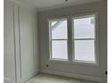 Living room featuring wainscoting, neutral gray paint, ample natural light from large windows, and clean design at 122 Sanderway Dr, Chapel Hill, NC 27516