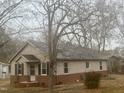 This charming single-story home has neutral siding, brick foundation, and a shingled roof at 128 Warren Ave, Oxford, NC 27565