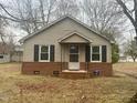 Charming single-story home featuring brick foundation and neutral siding with shutters at 128 Warren Ave, Oxford, NC 27565