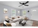 Bright living room featuring a large sectional sofa, neutral decor, and wood-look flooring at 128 Warren Ave, Oxford, NC 27565