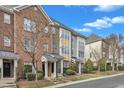 A row of brick and siding townhouses with manicured landscaping sits under a clear blue sky at 131 Dove Cottage Ln, Cary, NC 27519