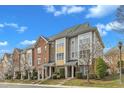 A row of brick and siding townhouses with manicured landscaping sits under a sky with scattered clouds at 131 Dove Cottage Ln, Cary, NC 27519