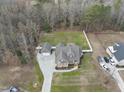 An aerial view of a beautiful property with a large lawn, garages, a long driveway, and mature trees at 1320 Blue Heron Dr, Nashville, NC 27856