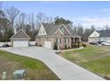 Gorgeous view of a brick home with a long driveway leading to two garages, surrounded by a well-kept lawn at 1320 Blue Heron Dr, Nashville, NC 27856