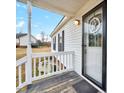 Close-up of a charming front porch with white railings and a decorative glass front door at 135 Stillmeadow Dr, Louisburg, NC 27549