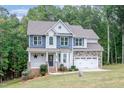 Beautiful two-story home with a lush green lawn, manicured landscaping, and a two-car garage at 1354 Red Bud Ct, Wake Forest, NC 27587