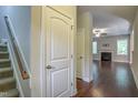 Inviting hallway with hardwood floors leads to the living room with a fireplace and staircase to the left at 1354 Red Bud Ct, Wake Forest, NC 27587