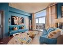 Bright and airy living room with blue walls, modern furnishings, and a balcony offering city views at 140 W Franklin St # 406, Chapel Hill, NC 27516
