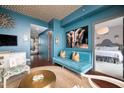 The living room features blue walls and ceiling with modern furniture, complemented by unique artwork and decor at 140 W Franklin St # 406, Chapel Hill, NC 27516