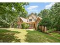 Beautifully landscaped front yard with a brick home in a wooded setting at 155 Georgetown Woods Dr, Youngsville, NC 27596