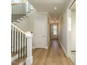 Bright entryway featuring hardwood floors, white trim, and staircase with black metal railing at 1800 Bright Lantern Way, Wendell, NC 27591