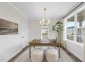 Well-lit office with wood desk, a modern chandelier, and views of the outdoors at 1800 Bright Lantern Way, Wendell, NC 27591