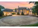 Circular driveway of this stone home featuring a portico leading to a three-car garage at 1801 Oatlands Ct, Wake Forest, NC 27587