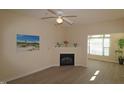 Bright living room with a fireplace, wood floors, a ceiling fan, and a large window at 2520 Friedland # 202, Raleigh, NC 27617