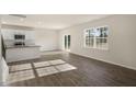 Open-concept living room with hardwood floors, a sliding glass door, and plenty of natural light at 2562 Summersby Dr, Mebane, NC 27302