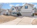 Inviting home with beige siding, green shutters, and a spacious driveway leading to a two-car garage at 32 Colson Dr, Garner, NC 27529